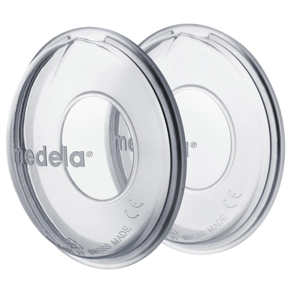 Zwei durchsichtige, runde Plastikscheiben mit der Aufschrift "medela".