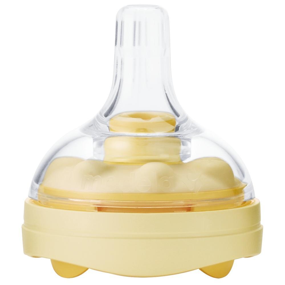 Ein gelber Babyflaschensauger mit durchsichtiger Kappe.