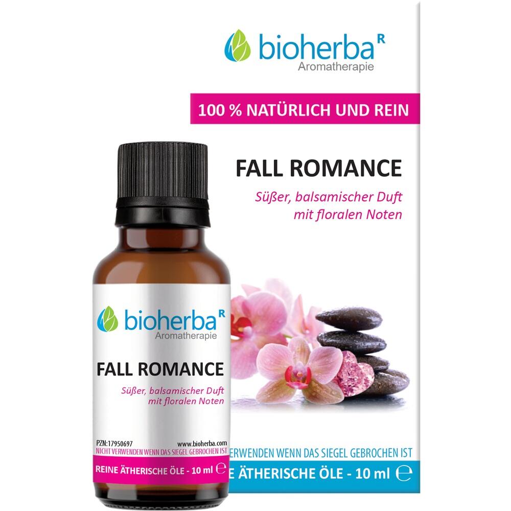 Eine Flasche ätherisches Öl mit dem Duft "Fall Romance" und rosa Blumen im Hintergrund.
